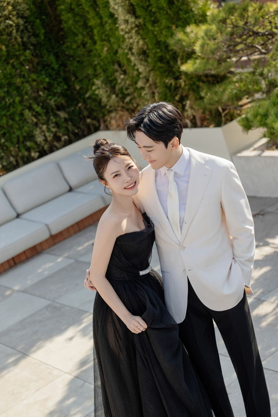 정원에서 서로 기대어 선 두 사람